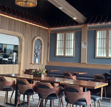 Rocky Maki dining room with wood-slat walls, shoji-style windows, pendant lights and wooden tables