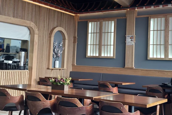 Rocky Maki dining room with wood-slat walls, shoji-style windows, pendant lights and wooden tables